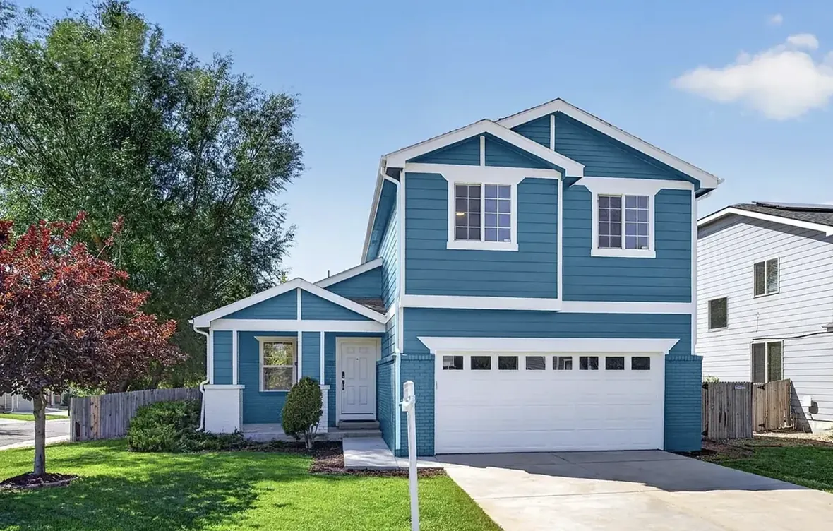 Two-story home in Thornton, Colorado repainted teal with white trim, as it stands today