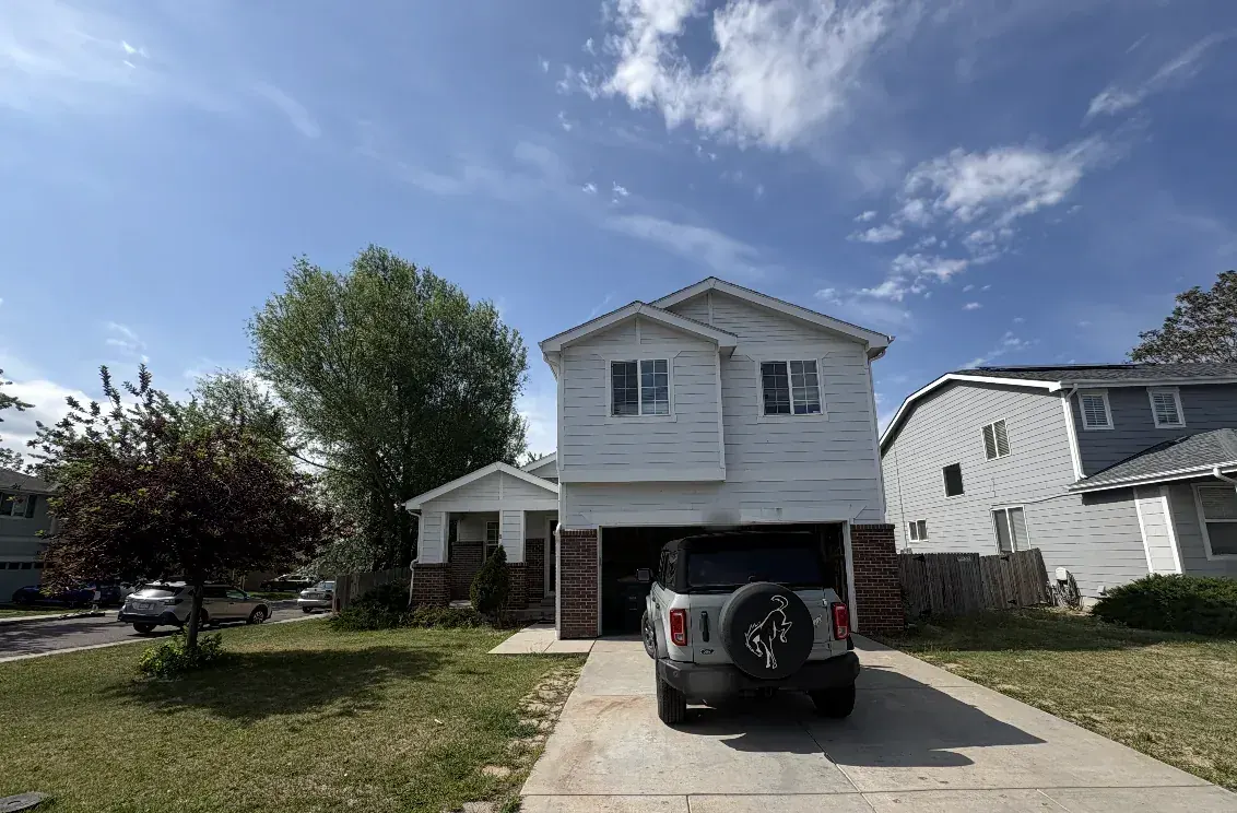 Two-story house with white siding before renovation, Thornton Colorado