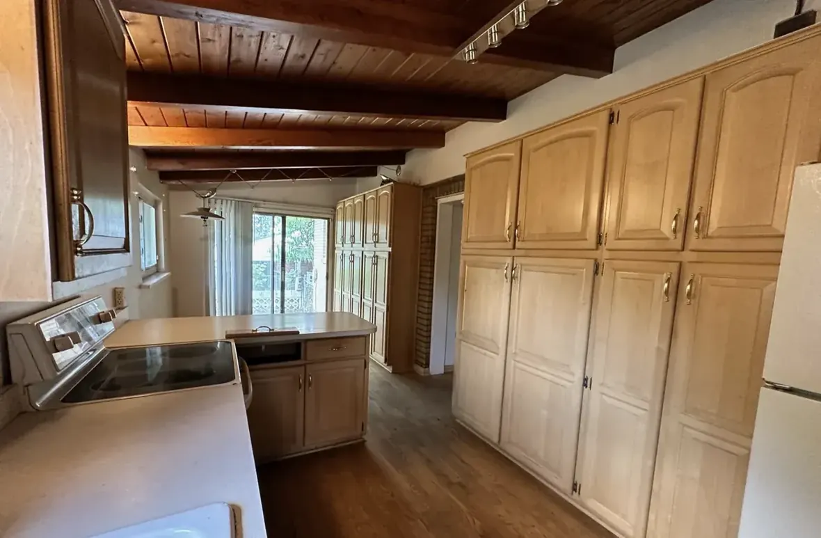 Dated kitchen with bleached oak cabinets under an original beamed plank ceiling, Westminster Colorado